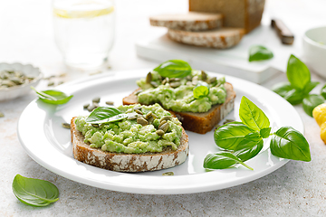 Image showing Avocado sandwich with pumpkin seeds. Healthy vegetarian avocado toast with rye bread for breakfast. Vegan menu