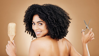 Image showing Hair care, portrait and a woman with a brush and scissors for grooming, styling or beauty. Smile, hairdresser and a young girl with an afro and tools for a hairstyle or cut on a studio background