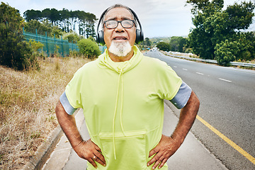 Image showing Outdoor, tired and senior man with fitness, headphones and fatigue with exercise, workout and sweating. Elderly person, runner or old guy with a headset, exhausted or breathing for wellness or health