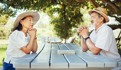 Image showing Man, woman and bible for prayer at table, together and bond in worship for religion with eyes closed. Mature couple, calm and peaceful in backyard for faith, support or trust of love for relationship