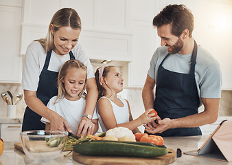 Image showing Love, cooking and family in the kitchen together for bonding and preparing dinner, lunch or supper. Happy, smile and girl children cutting vegetables or ingredients with parents for a meal at home.