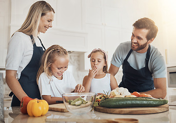 Image showing Bonding, cooking and family in the kitchen together for preparing dinner, lunch or supper. Happy, smile and girl children cutting vegetables or ingredients with parents for a meal at modern home.