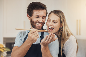 Image showing Couple, cooking and taste test in kitchen with romance, support and love in their home together. Food, spoon and man feeding woman in house while preparing a delicious meal with fun and bonding