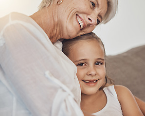 Image showing Love, hug and girl child with grandmother on a sofa hug, bonding and relax in their home together. Family, care and face of kid with senior woman in a living room for babysitting or weekend visit