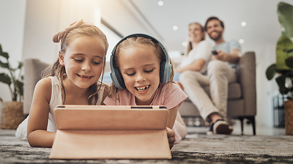 Image showing Children, tablet and relax on floor for home learning, watch video and games with headphones and parents in living room. Girl listening to audio for digital school, family movies or film on carpet