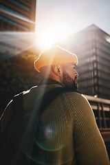 Image showing Back, thinking and man in a city, fashion and lens flare with ideas, planning and decision. Person, gen z and guy outdoor, sunshine and backpack with buildings, fashion and choice with casual outfit