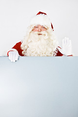 Image showing Santa claus, poster and promotion space for holiday special, branding or mockup. Father Christmas, portrait and wave for presenting billboard on white background for marketing, sales for winter beak