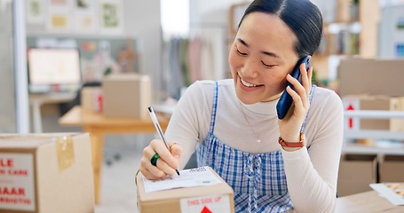 Image showing Ecommerce, Asian woman with phone call and package, writing and checking sales and work at fashion startup. Online shopping, boxes and small business owner with smartphone, orders and networking.