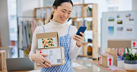 Image showing Package, startup and Asian woman with phone for business at a fashion retail boutique. Networking, technology and young female entrepreneur with cardboard boxes and cellphone for delivery information