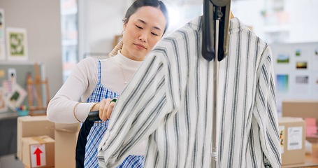 Image showing Asian woman, fashion designer and steam clothing in logistics, small business or quality service at boutique. Female person in dry cleaning, retail store or product preparation for delivery at shop