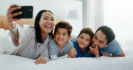 Image showing Family selfie, laughing and in a home bedroom for a memory, happy and comedy together. Smile, love and a young mother, father and children taking a photo on a bed in the morning for care and fun