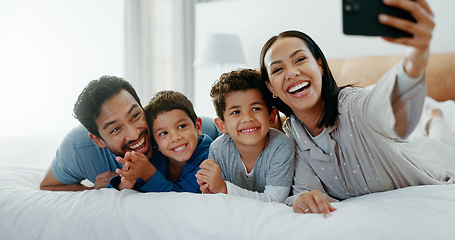 Image showing Family selfie, laughing and in a home bedroom for a memory, happy and comedy together. Smile, love and a young mother, father and children taking a photo on a bed in the morning for care and fun