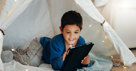 Image showing Tablet, relax and boy child in a tent playing an online game on the internet in the living room. Happy, entertainment and kid watching a movie, video or show on a digital technology in a blanket fort