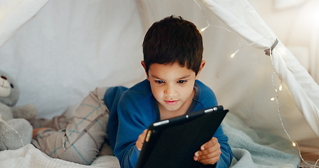 Image showing Tablet, relax and boy child in a tent playing an online game on the internet in the living room. Happy, entertainment and kid watching a movie, video or show on a digital technology in a blanket fort