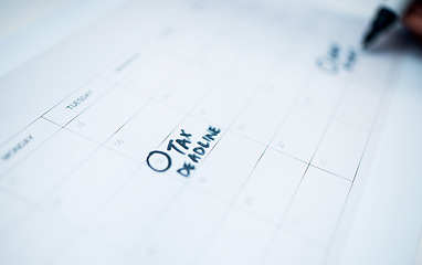 Image showing Person, calendar and date for tax, deadline or reminder in schedule planning or strategy on desk at office. Closeup of writing, paper or agenda for memory, financial plan or daily tasks at workplace