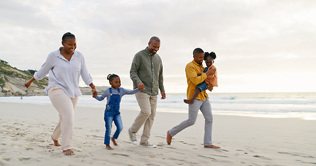 Image showing Happy, walking and a black family at the beach, holding hands and talking on a holiday. Sunset, conversation and grandparents, father and children on a walk by the sea during a vacation for travel