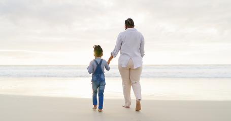 Image showing Black family, mother and daughter holding hands, beach and bonding with love and care, back view and walk outdoor. Sea, freedom and travel, woman and girl on holiday with trust and support in nature
