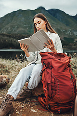 Image showing Tablet, reading and woman hiking with backpack in nature on mountain for adventure and weekend trip. Digital technology, bag and female person from Canada checking information and trekking in forest.
