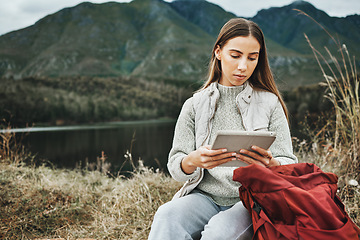 Image showing Tablet, backpack and woman hiking in nature on mountain for adventure, weekend trip or vacation. Digital technology, bag and female person from Canada network on social media and trekking in forest.