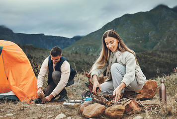 Image showing Happy couple, campfire and set up tent in nature for vacation, holiday and travel together. Camping, man and woman outdoor preparing for adventure, hiking and trekking in the countryside for freedom