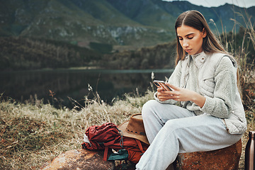 Image showing Nature, phone and young woman hiking on a mountain and network on social media or mobile app. Travel, technology and female person from Canada scroll on internet with cellphone in outdoor forest.
