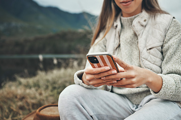 Image showing Mountain, hands and closeup of woman on a phone networking on social media, mobile app or the internet. Technology, nature and female person typing a text message on cellphone in the countryside.