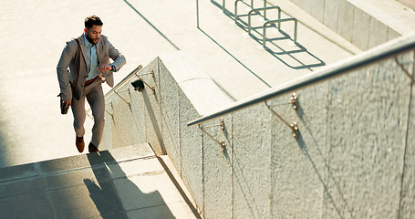 Image showing Business, city and man on the stairs, late and running with appointment, schedule and stress. Person outdoor, professional or employee check time, steps or travel with worker, rush or speed to office