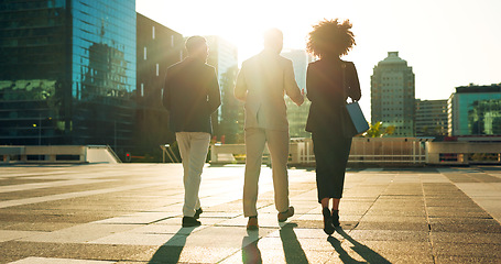 Image showing Back, business team and walking outdoor in city for morning travel to work, conversation and lens flare. Rear View, professional workers and moving in urban town with communication and networking