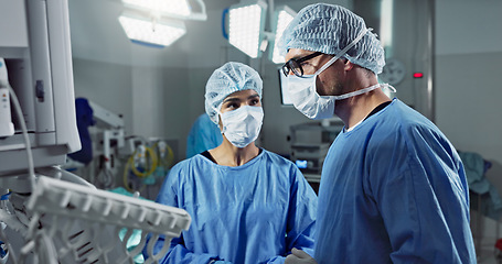 Image showing Medical team, people and doctor in operating room to talk, strategy and pointing at screen for surgery. Man, woman and scrubs in healthcare with equipment in theatre with monitor for xray of patient