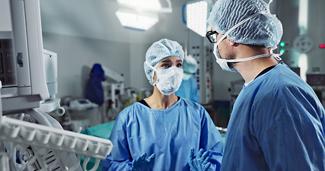 Image showing Medical team, people and doctor in operating room to talk, strategy and pointing at screen for surgery. Man, woman and scrubs in healthcare with equipment in theatre with monitor for xray of patient