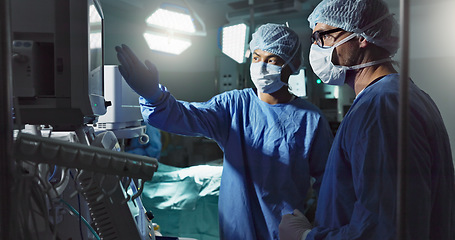 Image showing Planning, talking and surgeons in a room for surgery, teamwork and discussion about healthcare. Dark, theater and men or doctors speaking about schedule for a procedure on a screen for operation