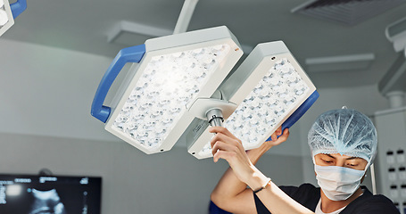 Image showing Assistant, surgery and nurse with surgical light for medical emergency treatment in the hospital ER or clinic. Professional, healthcare and worker doing operation, transplant and with medicine tools