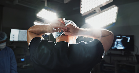 Image showing Surgery, prepare and doctor tie mask in operating room for medical service, protection and operation. Healthcare team, safety scrubs and person with uniform for emergency, procedure and wellness