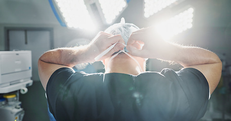 Image showing Surgery, preparation and doctor tie mask in operating room for medical service, protection and operation. Healthcare ppe, safety scrubs and person with uniform for emergency, procedure and wellness