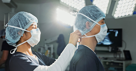 Image showing Surgery, hospital and doctors tie mask in operating room for medical service, preparation and operation. Healthcare team, safety scrubs and people with uniform for emergency, procedure and protection