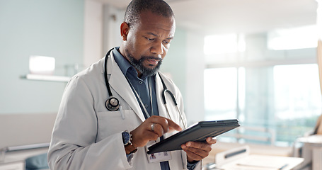 Image showing Healthcare, typing and a black man or doctor with a tablet for a medical app or communication. Mature, reading email and an African surgeon with technology for results, information or surgery advice