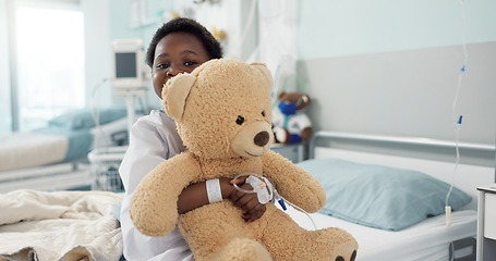 Image showing African boy child, hospital and teddy bear on bed with face, smile and rest for recovery for healthcare treatment. Patient kid, happy and portrait to relax, clinic and hug with toys after surgery