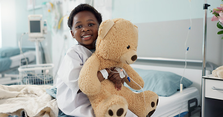 Image showing African boy child, hospital and teddy bear on bed with face, smile and rest for recovery for healthcare treatment. Patient kid, happy and portrait to relax, clinic and hug with toys after surgery