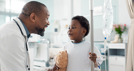 Image showing Pediatrician, happy and doctor playing with child as care, support and kindness in healthcare in a hospital or clinic. Iv drip, teddy bear and African professional with medical compassion for kid