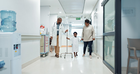 Image showing Medical, pediatrician and a doctor walking with a black family in a hospital corridor for diagnosis. Healthcare, communication and consulting with a medicine professional talking to a boy patient