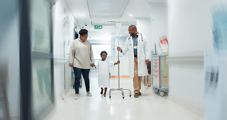 Image showing Medical, pediatrician and a doctor walking with a black family in a hospital corridor for diagnosis. Healthcare, communication and consulting with a medicine professional talking to a boy patient