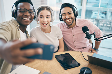 Image showing Podcast, smile and group selfie of friends together bonding, live streaming and people recording broadcast in studio. Happy team of radio hosts take picture at table for social media or collaboration