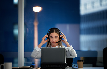 Image showing Business woman, call center and headphones at night for communication, ready for telemarketing and sales in office. Professional agent, consultant or worker start job, telecom or ecommerce on laptop