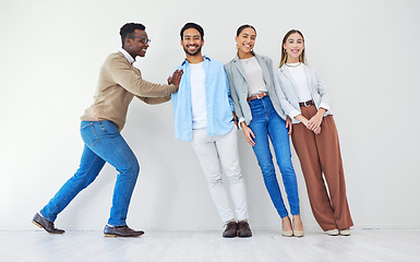 Image showing Black man pushing team of business people, portrait and smile in office together for synergy. Strong professional support group of employees, solidarity for collaboration and cooperation in startup