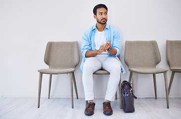 Image showing Waiting room, recruitment and man in an office for interview in job search for appointment. Hiring, career and Indian male person sitting on chair for meeting with human resources in modern workplace