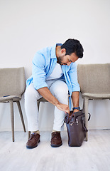 Image showing Bag, search and man in waiting room for interview, hiring and recruitment with lost resume in briefcase. Stress, finding and person forget laptop or keys by mistake, frustration and worried in office