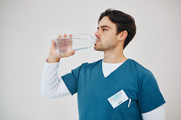 Image showing Nurse drink water in bottle for health, wellness or body nutrition in studio isolated on a white background in hospital. Man, medical professional or hydration with liquid of thirsty surgeon on break