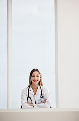 Image showing Portrait, doctor and space with a woman arms crossed in a hospital for healthcare, consulting or trust. Medical, smile and a happy young medicine professional at a desk in a clinic for cardiology