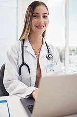 Image showing Portrait, doctor and laptop with a woman in a hospital for healthcare, consulting or trust. Medical, smile and a happy young medicine professional typing at a desk in a clinic for cardiology