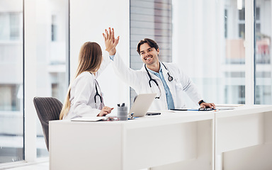 Image showing Doctors, healthcare and high five for collaboration with smile at desk for planning, research and medical work in hospital. Medicine, man or woman with teamwork, coworkers or happiness for cardiology